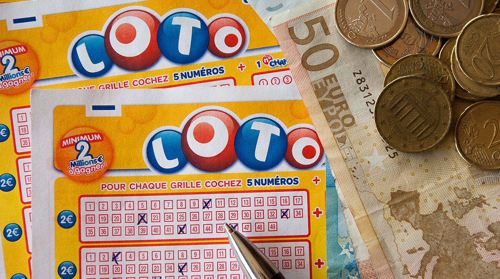 Un biglietto del lotto con numeri spuntati, una penna e soldi su un tavolo.