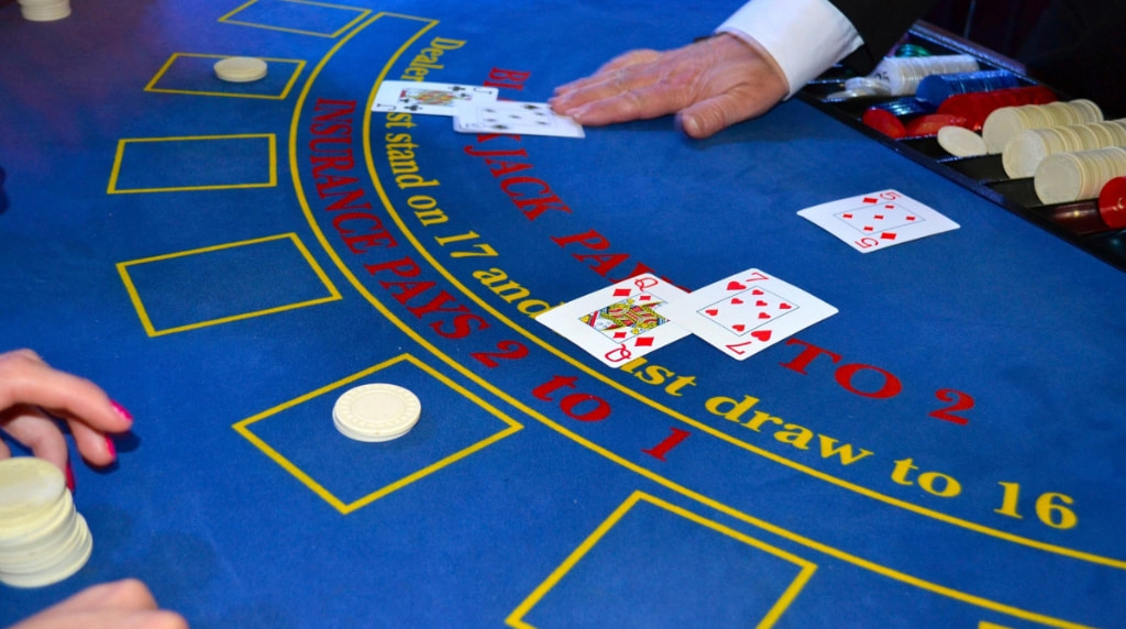 Tavolo di blackjack con croupier e giocatore che punta.