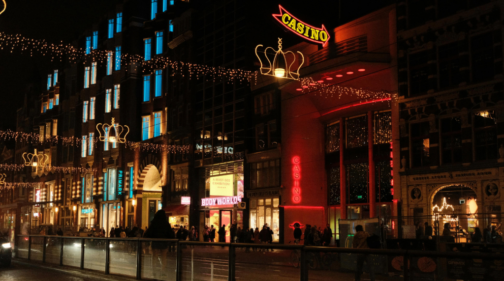 Straat in Amsterdam in de avond, inclusief kerstverlichting en neon letters met het woord casino.