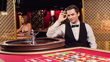 A live casino dealer ready to host a game at an online operator