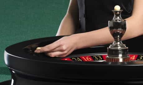 a hand throwing a roulette ball into the wheel.
