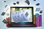 A laptop bursting with playing cards.