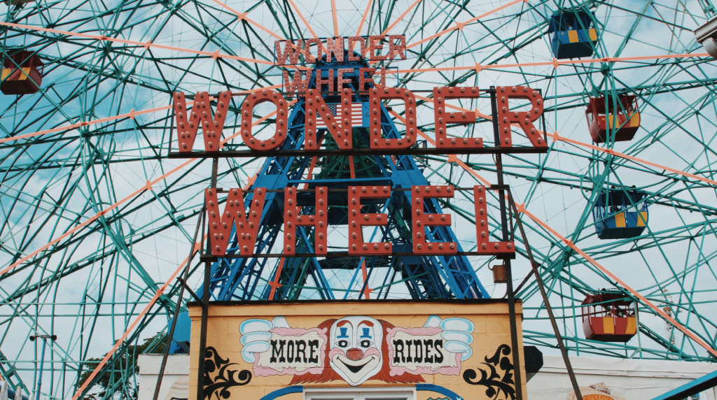 Coney Island Ferris Wheel against blue sky.