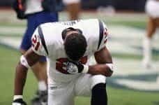 American football player drops to his knees during a game.