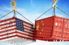 Two shipping containers, with the American and Chinese flags, crashing into each other.
