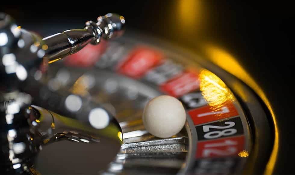 A ball sitting in a roulette wheel pocket.