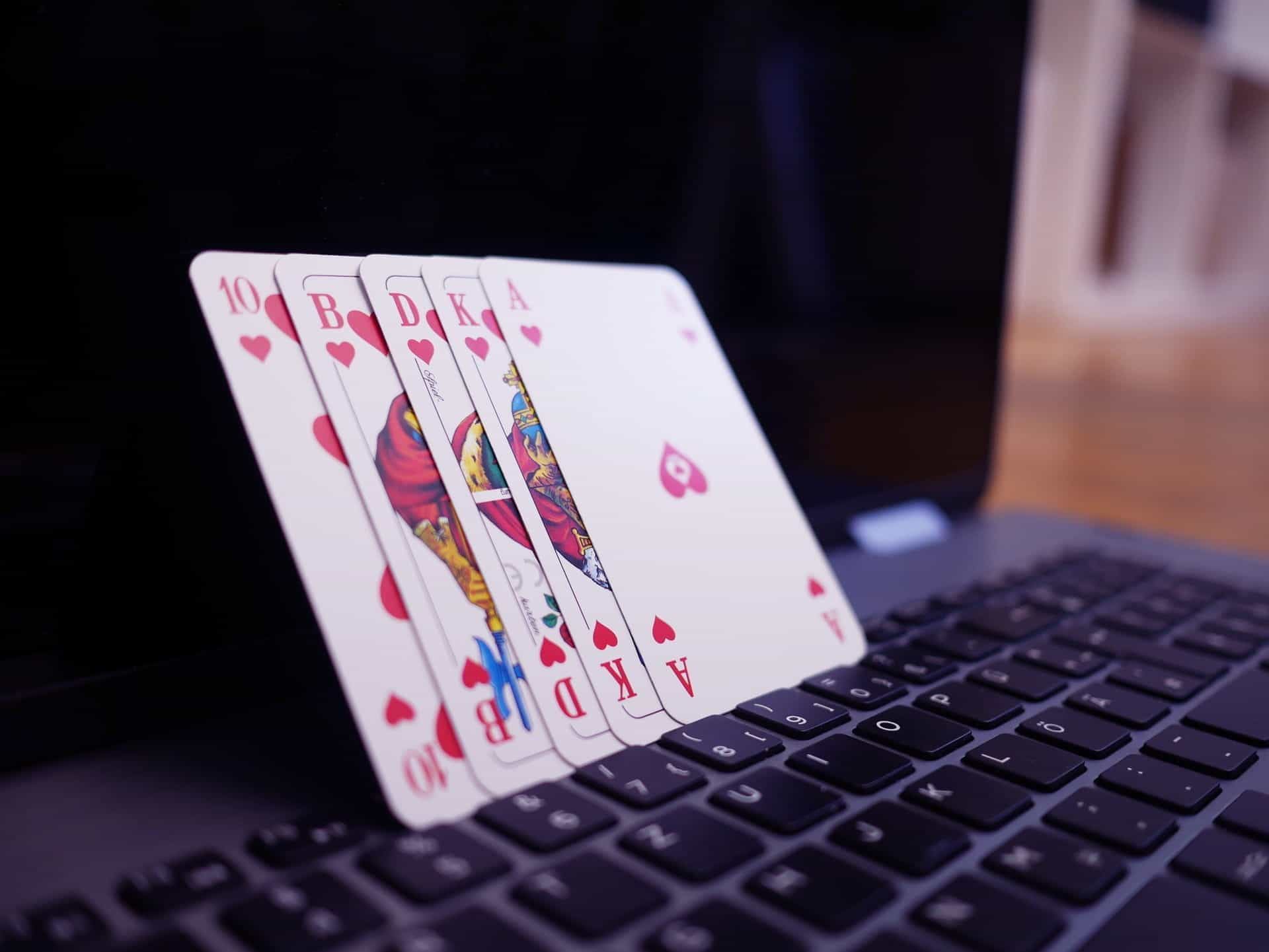 Playing cards balanced on a laptop.