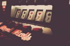 Royal Flush slot machine in a dimly lit casino displays card symbols.