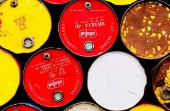 A colorful closeup of red, yellow, white, and brown barrels containing oil.