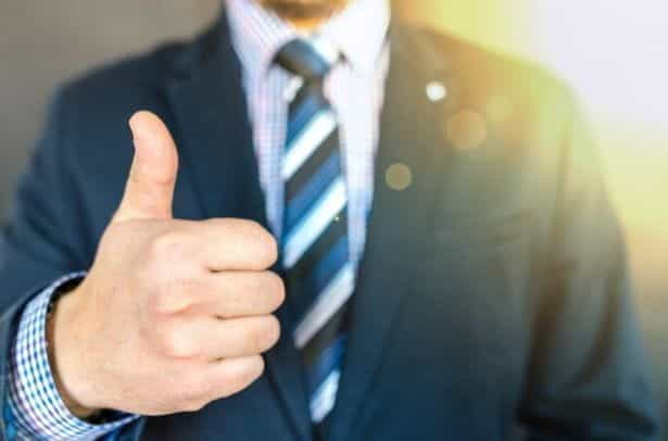 Businessman in suit with thumbs up.