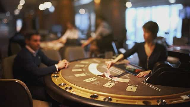 A blackjack dealer lays out her cards on a card table.