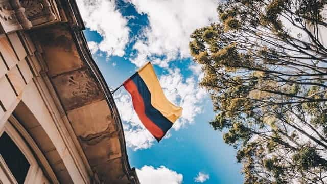 The Colombian flag waves high up between two buildings.