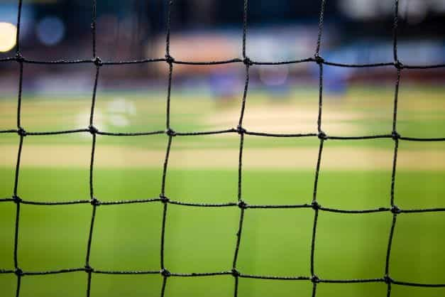 A black colored goal net on a soccer field.