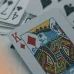 A king of diamonds placed on top of a deck of out of focus cards.