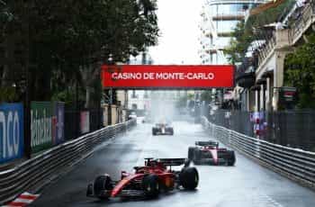 Charles Leclerc racing on wet Monaco streets in 2022.