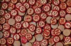 Painted red wooden bingo tiles spread across a flat surface.