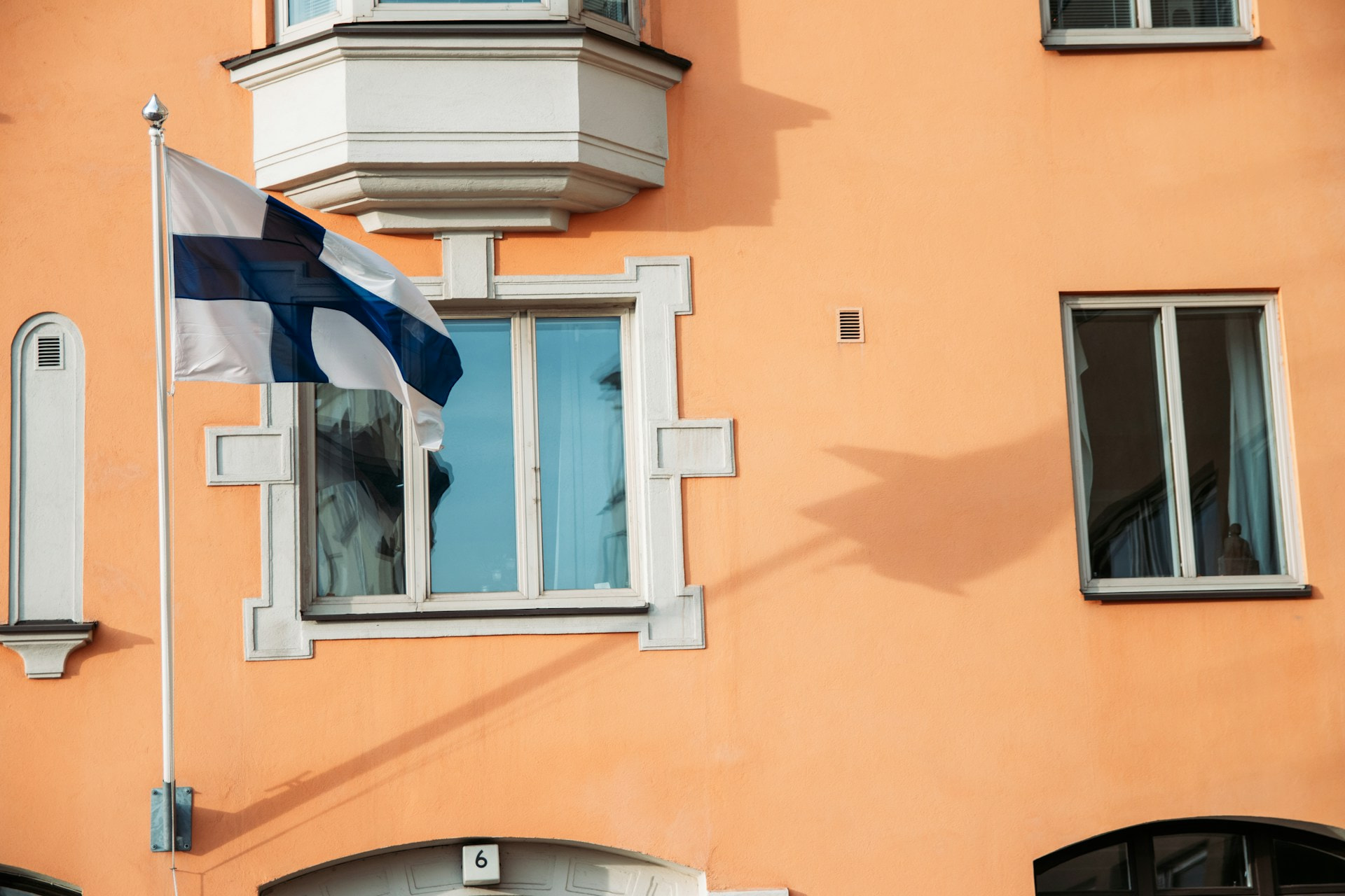 An unfurled flag in the wind against a blue sky.