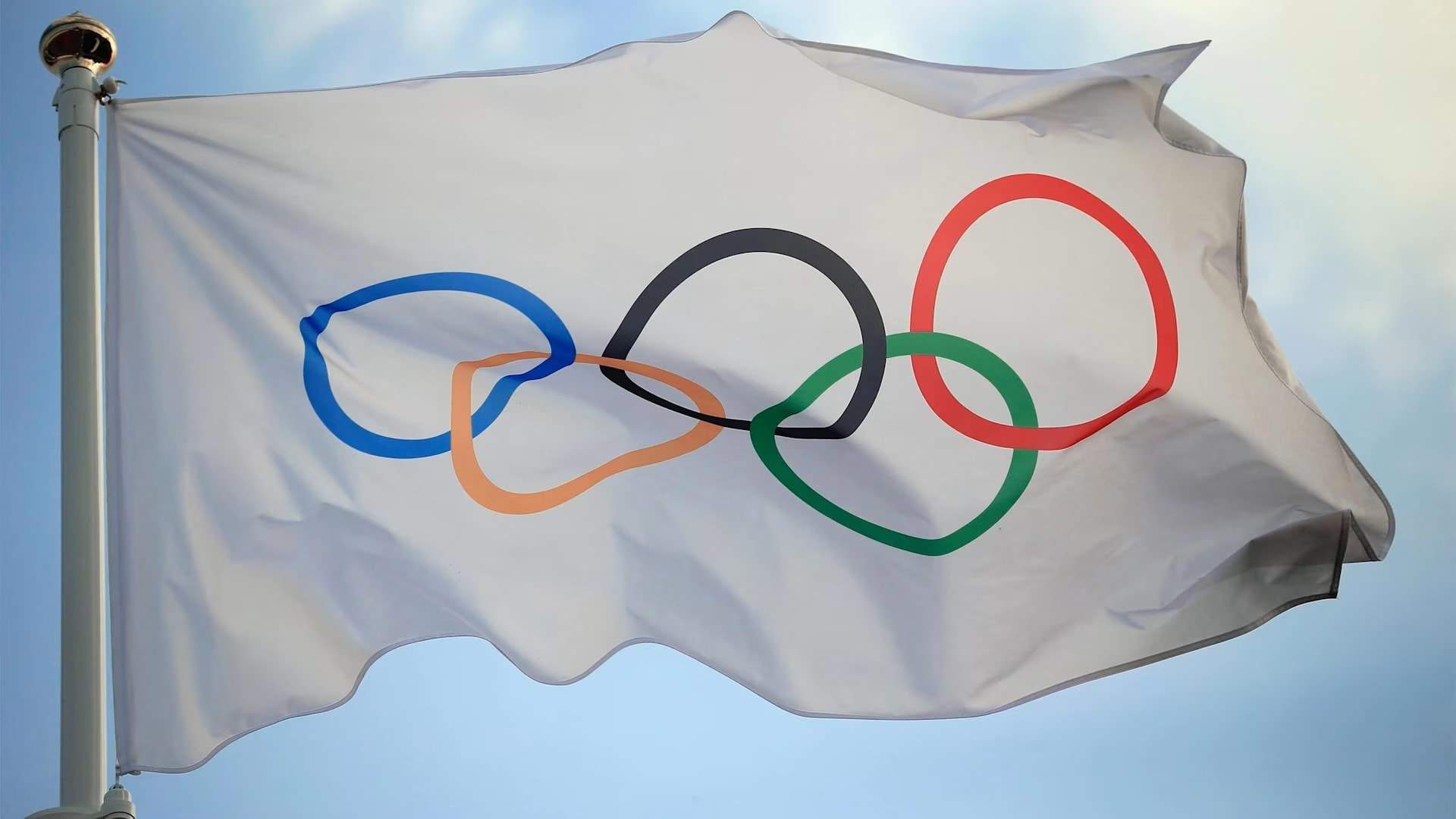 The Olympic flag flutters in the wind.