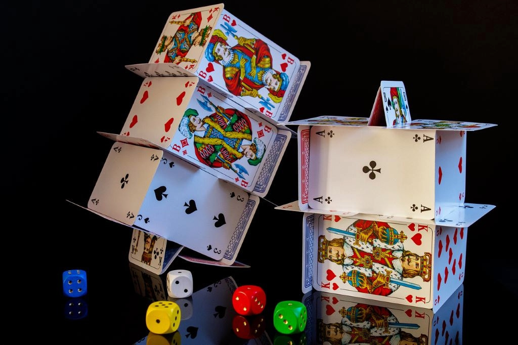 An image showing card towers and colourful dice.