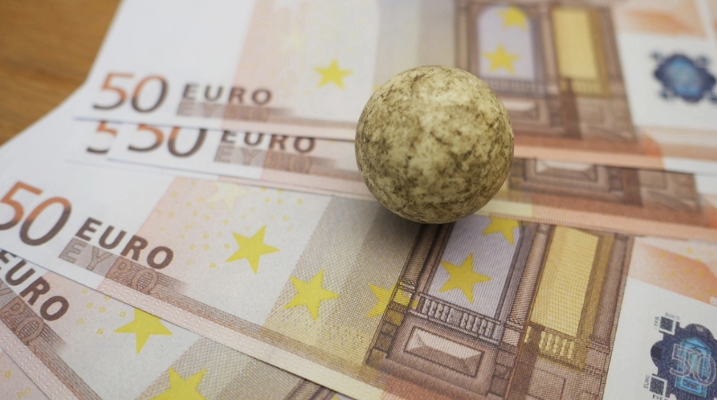 Euro Banknotes with a Stone on Top to Limit Them