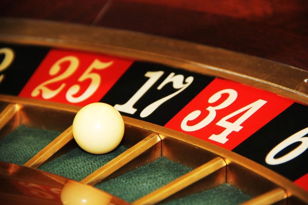 An image showing a roulette wheel with a ball at a casino.