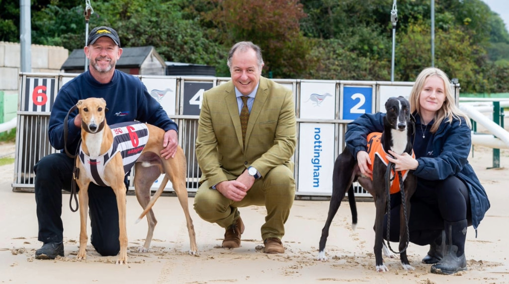 GBGB Chief Executive Mark Bird flanked by two racing greyhounds and their handler