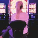 A Woman sitting at Slot machine in a Casino