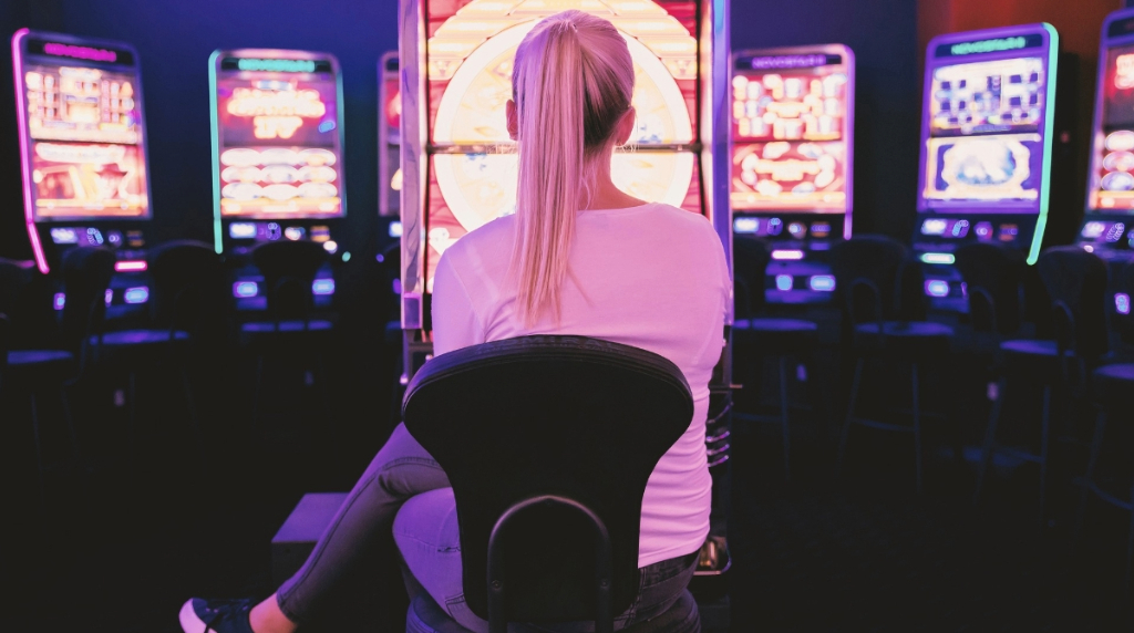 A Woman sitting at Slot machine in a Casino