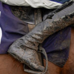 A mud splattered horse and rider's boot pictured at Fontwell Park in March, 2024