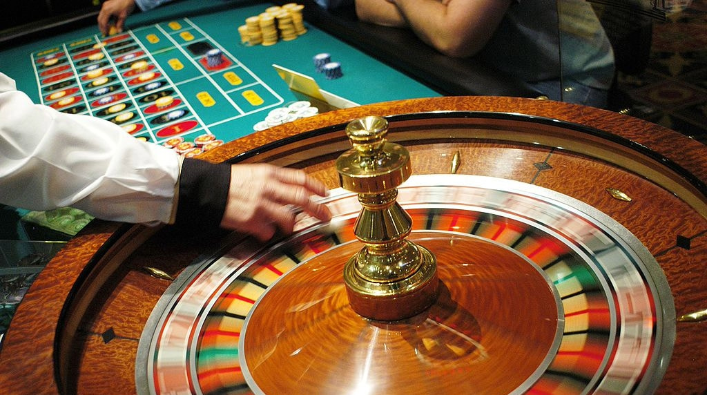 A Roulette Wheel Spins as Chips Are Placed on a Table Layout