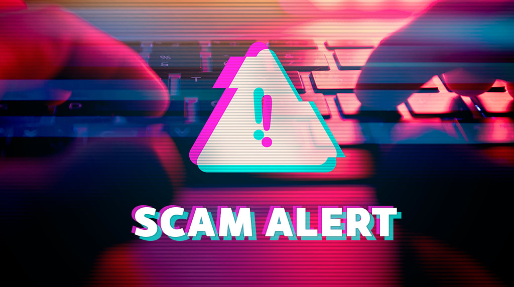 Mysterious hands typing on a computer keyboard with a warning sign and the words SCAM ALERT written across