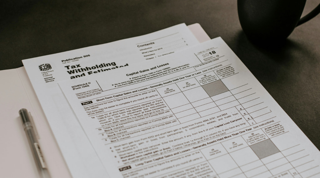 Folder filled with IRS forms beside a cup of coffee