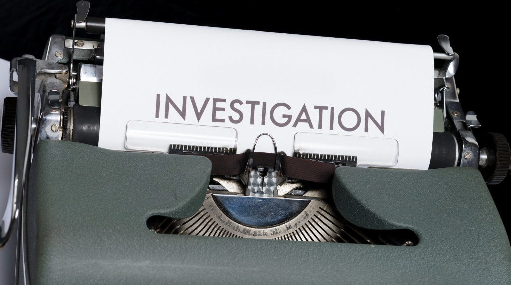 A typing machine with Investigation written on a piece of paper