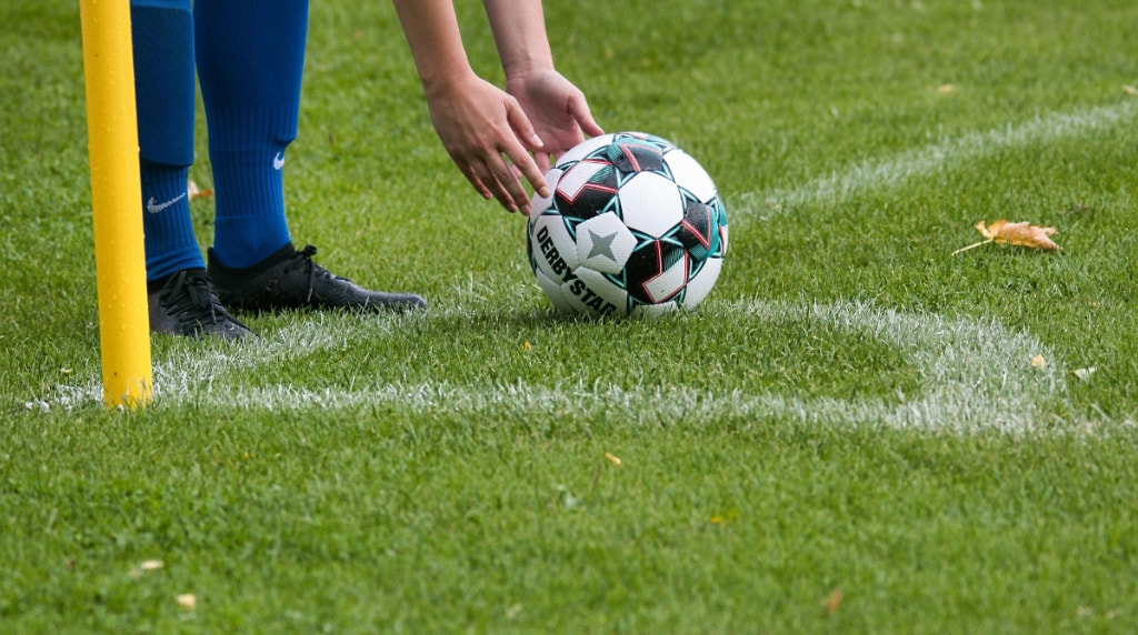 Player Placing a Football Onto the Pitch, Ready to Be Kicked