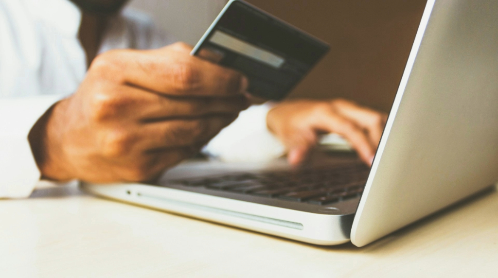 Person entering their credit card data into a computer